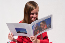 a little girl reading a book The Christmas story 