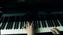 a man playing keys on a piano 