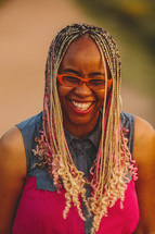 Smiling African-American woman with blonde and pink braids 