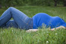 pregnant woman lying in the grass 