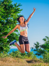 Portrait of young pretty sporty athletic woman on sea summer nature background. Lady after workout.