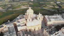High aerial 4k drone footage circling the Roman Catholic Parish Church of Sacro Cuor in Sliema, Malta, a densely populated town on an island of the Mediterranean Sea.