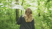 A woman walking through the woods 