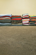 Stacks of folded clothes on the floor