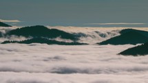 Panoramic view of misty mountains forest above foggy clouds in sunny nature landscape Time lapse
