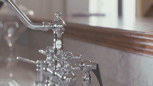Tracking shot of a silver faucet in a luxury kitchen