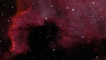 Zoom out of a large colorful nebula in deep space