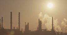 silhouette of a large scale oil refinery during sunrise