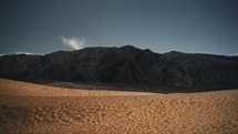 Dunes in the desert with mountains in the background