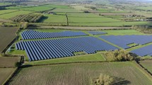 Large solar power plant on a picturesque green field. Solar panels in aerial view. 