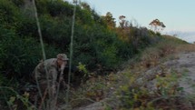 Alone soldier comes out of dense vegetation