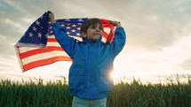 Happy american little boy patriot kid with national flag on sky background. Symbol of democracy, independence, USA, future. 4th July celebration, US banner, memorial Veterans, election, America, labor