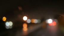 bokeh taillights from cars on a wet road at night 
