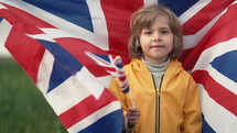 Little child son, british patriot kid waving Union Jack flag outdoors. High quality 4k footage