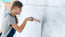 Female artist painting mural on a wall