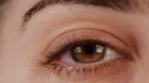 Macro shot of a woman's brown eye opening