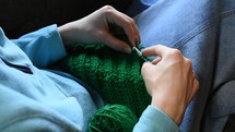 woman knitting green yarn 