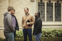 group of men standing in front of a church before a Bible study
