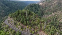 Aerial pullback of a curvy highway through a scenic canyon