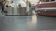 Passengers collecting luggage from a conveyor belt at the airport.