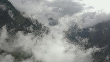 Aerial drone flying through the clouds in mountains