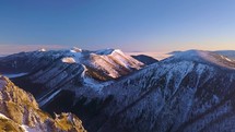 Aerial view of colorful snowy alps mountains in cold winter morning hiking in top peak
