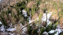 Aerial top down view of a river within the forest in winter - reveal shot