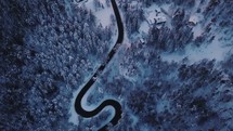 aerial view over a curvy road in snow 
