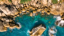 Drone aerial view over long rocky coastline. Amazing sea waves crashing on rocks seascape