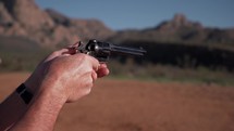 A man target shooting with a western style gun