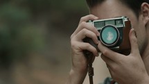 a man adjusting the lens of a camera 