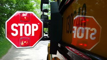 A school bus stop sign opening and closing