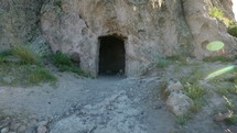 Aerial pullback of a cave or portal in solid rock that resembles the tomb of Jesus