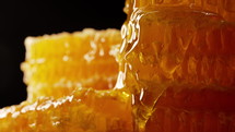 Raw honeycombs with pouring pure golden honey elixir. Macro texture, structure of flower nectar. High quality