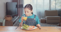 Girl eating healthy food and drinking orange juice.