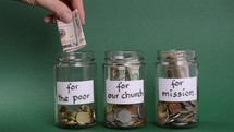 hands diving money between jars to do good 