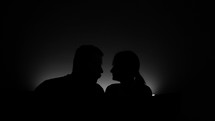 The Silhouettes of a Couple's Faces in Close Proximity - Close Up	