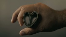 A man holding money shaped like a heart in his hand.
