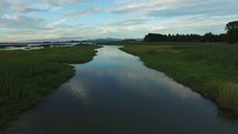 Aerial Video of Birds Flying Over Marsh Waters with Reflection of Sky and Clouds