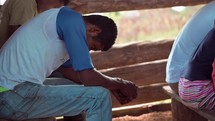 Man praying on a bench in a small church service in Honduras