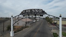 A panning aerial shot of a sign at the entrance to Fresno