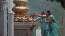 Women worshiping Hindu idols at an altar at The Varaha Lakshmi Narasimha Hindu temple.