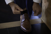 a man tying his dress shoes 