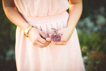 a woman holding purple flowers 