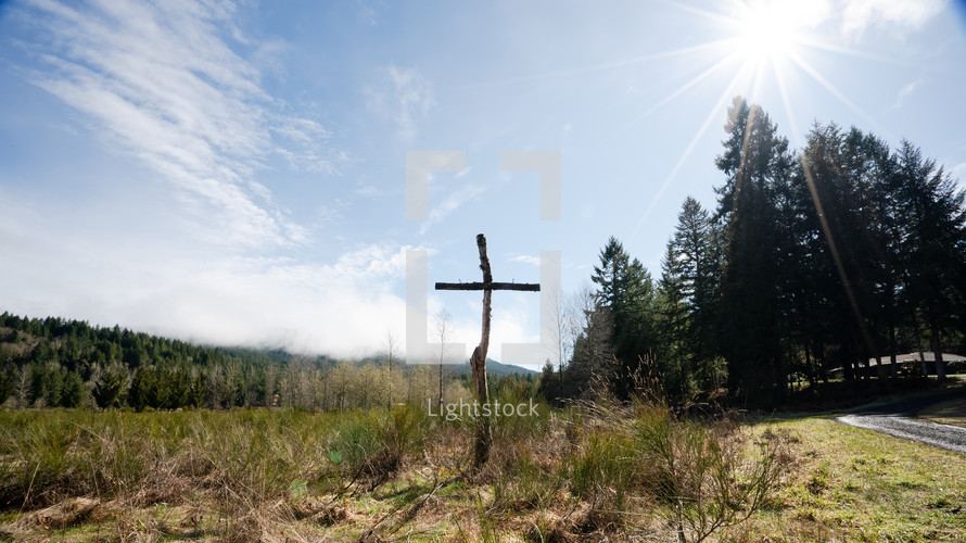 Wide shot of a cross with nails on a sunny day