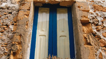 Rustic wall of house and Blue painted window of Sicily city