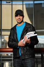 college student holding a stack of books 