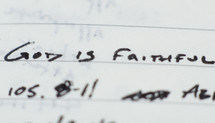 "God is faithful" written in ink on notebook paper.