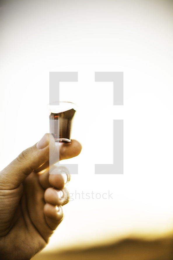 outside communion - fingers holding a communion wine cup
