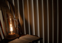 lantern in a chair and opened Bible 